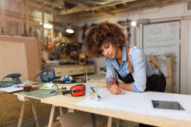 Onun atölyesinde çalışan Afro Amerikalı kadın craftswoman