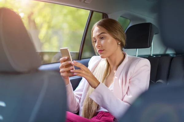 車でスマート フォンを持つ女性 — ストック写真