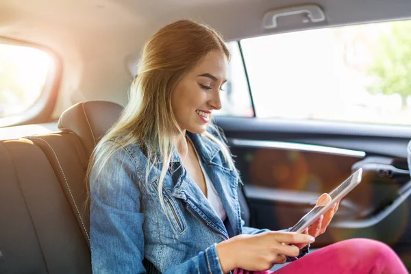 若い女性の車でタブレットを使用して — ストック写真