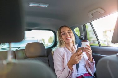 Kadın bir arabada akıllı telefon ile