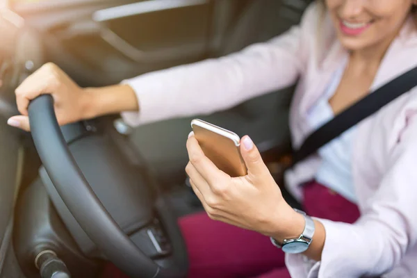 車でスマート フォンを持つ女性 — ストック写真