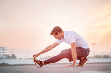 Genç adam dışarıda egzersiz yapıyor.