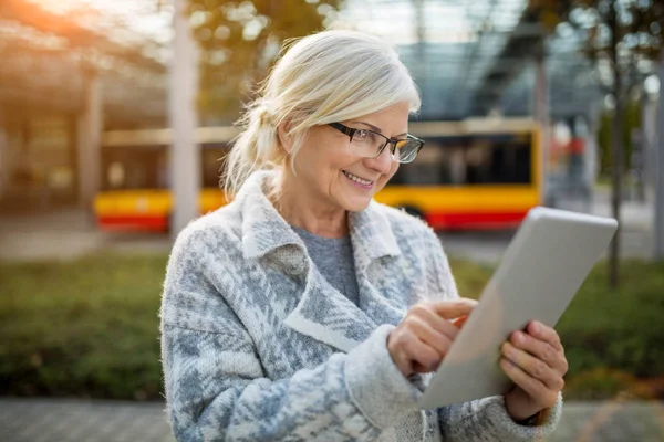 Senior Kobiety Pomocą Tabletu Czekając Autobus — Zdjęcie stockowe