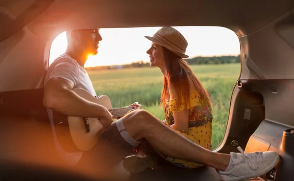 Jovem Casal Sentado Seu Carro Tronco Assistindo Pôr Sol — Fotografia de Stock