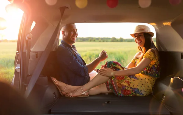 Pareja Joven Sentada Maletero Coche Mirando Atardecer —  Fotos de Stock