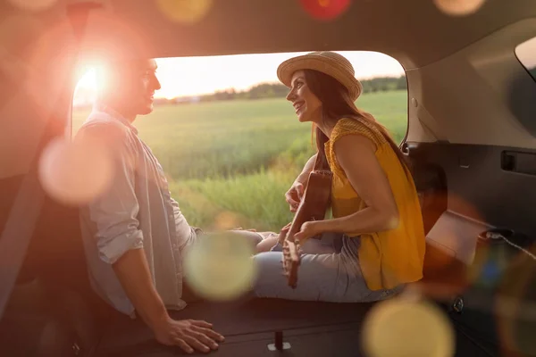 Jovem Casal Sentado Seu Carro Tronco Assistindo Pôr Sol — Fotografia de Stock