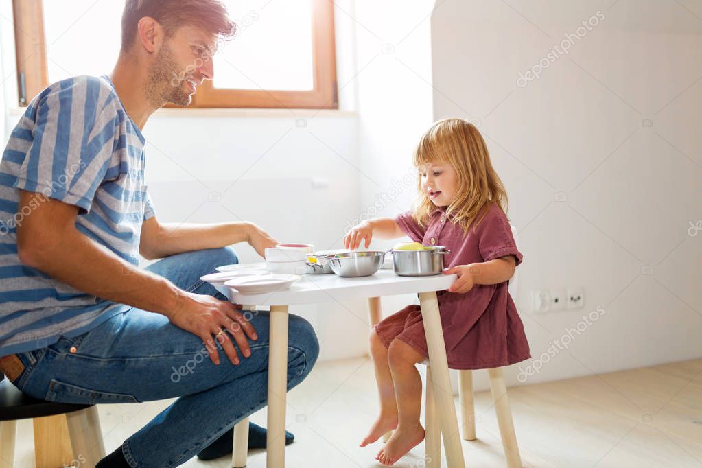Father and daughter having a tea party at home