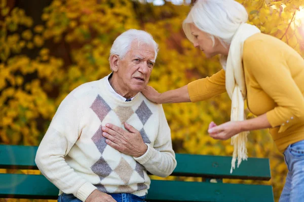 Ανώτερος Άνθρωπος Βιώνει Πόνο Στο Στήθος Ενώ Ανώτερος Γυναίκα Παρηγορεί — Φωτογραφία Αρχείου