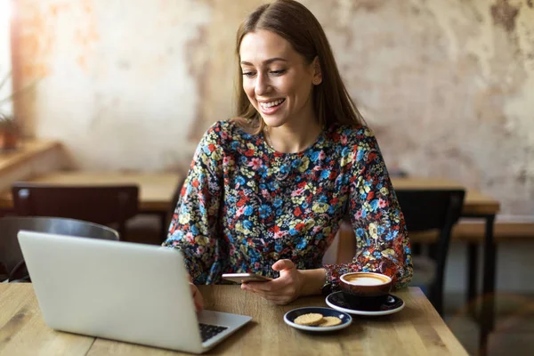 カフェにノートパソコンを持った若い女性が — ストック写真