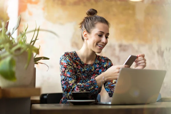 カフェにノートパソコンを持った若い女性が — ストック写真