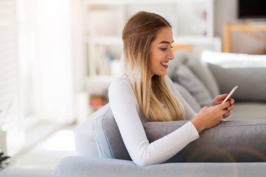 Genç kadın onun smartphone evde kullanma