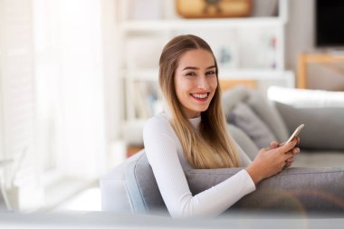 Genç kadın onun smartphone evde kullanma