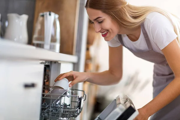 食器洗い機に皿を置く女性 — ストック写真