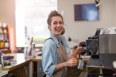 Genç barista onu kafe sayaç müşteriler için kahve hazırlamak