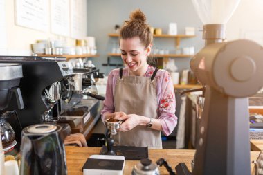 Genç barista onu kafe sayaç müşteriler için kahve hazırlamak