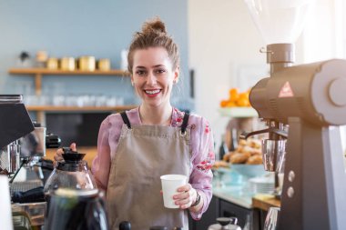 Genç barista onu kafe sayaç müşteriler için kahve hazırlamak