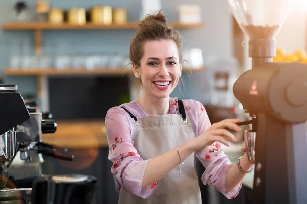 年轻的咖啡师在她的咖啡店为顾客准备咖啡 — 图库照片