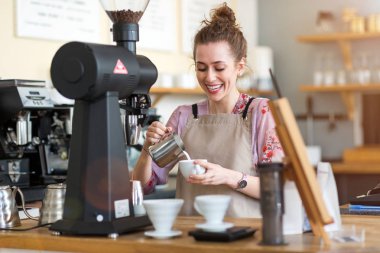 Genç barista onu kafe sayaç müşteriler için kahve hazırlamak