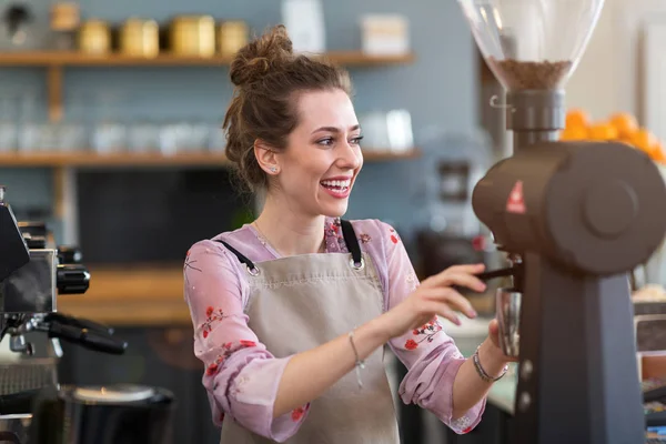 彼女のカフェカウンターで顧客のためのコーヒーを準備若いバリスタ ロイヤリティフリーのストック画像