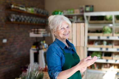 Küçük bakkal içinde dijital tablet ile mağaza asistanı