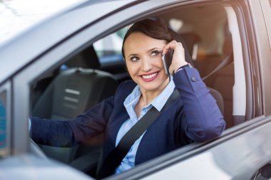 Bir araba sürüş sırasında akıllı telefon kullanan kadın