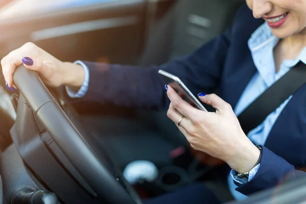 Kobieta Pomocą Smartfona Podczas Jazdy Samochodem — Zdjęcie stockowe