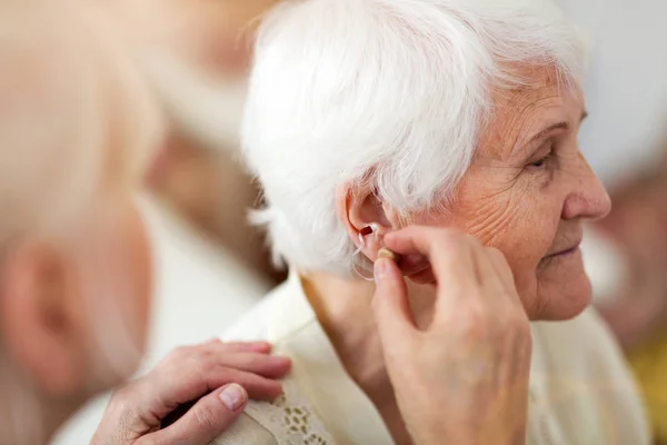 Kvinnlig Läkare Som Ansöker Hörapparat Till Senior Woman Ear — Stockfoto