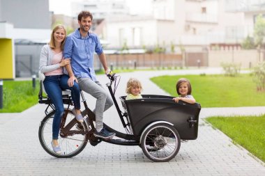 Young family having a ride with cargo bike clipart