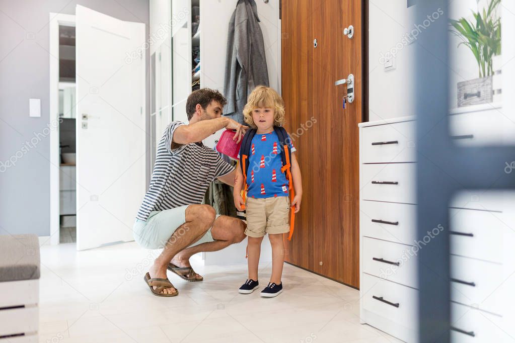 Father helping son get ready for school