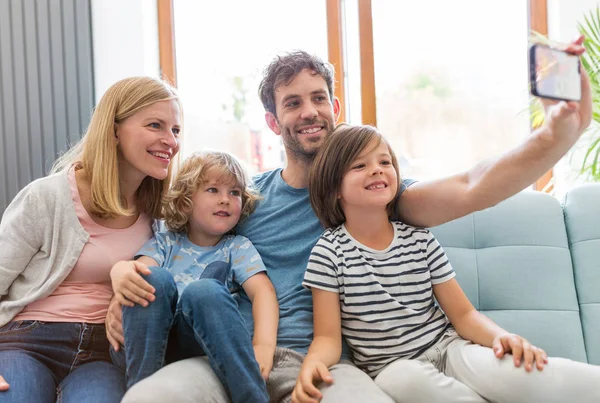 Família Tomando Selfie Enquanto Senta Sofá Casa — Fotografia de Stock