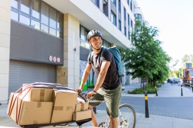 Bicycle messenger making a delivery on a cargo bike clipart