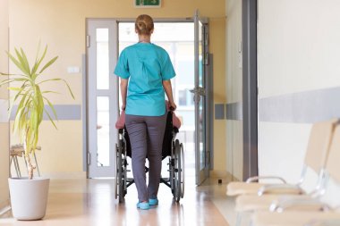 Hastanede hemşire ile tekerlekli sandalyede kıdemli kadın