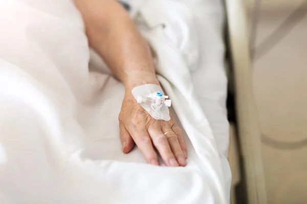 病院での点滴を持つ患者のトリミング画像 — ストック写真