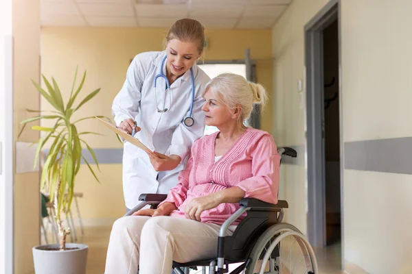 坐在轮椅上的老年妇女 医院内有护士 — 图库照片
