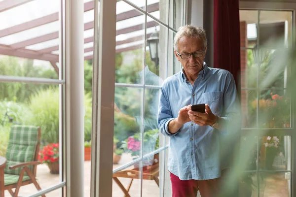 Starší Muž Používající Mobilní Telefon Doma — Stock fotografie