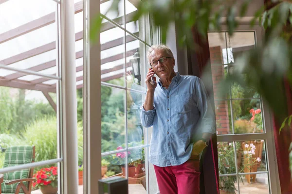 Hombre Mayor Usando Teléfono Móvil Casa —  Fotos de Stock