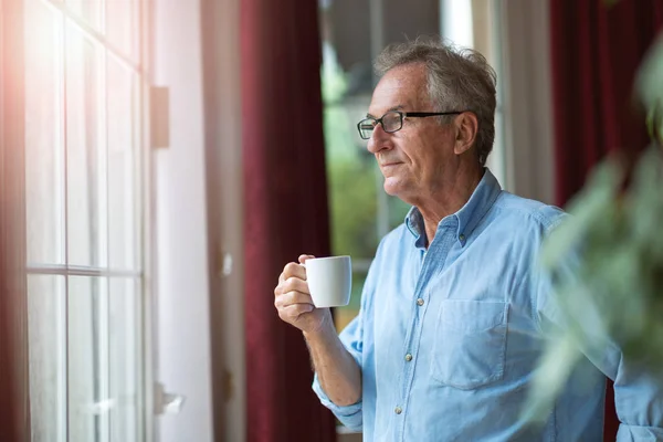 Ontspannen Volwassen Man Thuis Staande Door Het Raam — Stockfoto