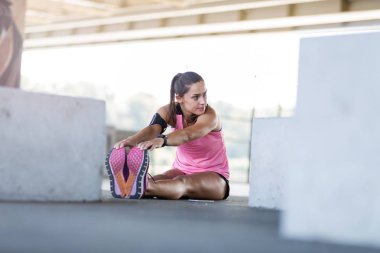 Genç kadın kentsel alanda germe egzersiz yapıyor