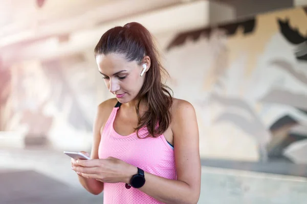Kvinnlig Löpare Med Smartphone Ett Urbant Stadsområde — Stockfoto