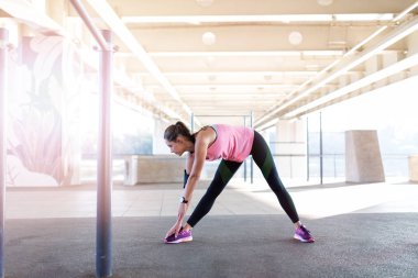 Genç kadın kentsel alanda germe egzersiz yapıyor