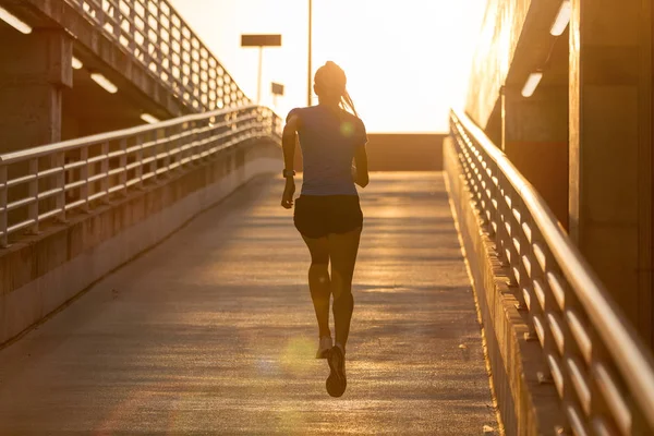 Genç kadın gün batımında şehirde park düzeyinde çalışan