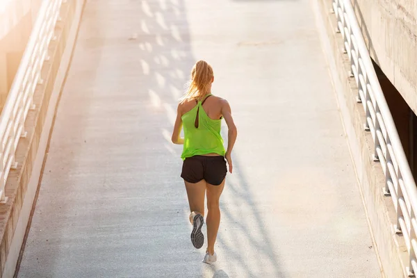 Genç kadın gün batımında şehirde park düzeyinde çalışan