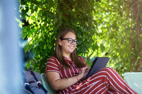 公園にタブレットを持っている若い女性は — ストック写真