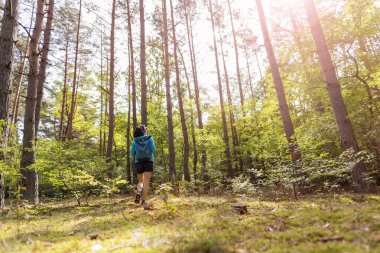 Ormanda yürüyüş yapan genç bir kadın.
