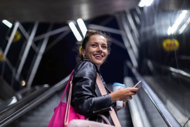 Bir şehir şehir bölgesinde gece akıllı telefon ile genç kadın