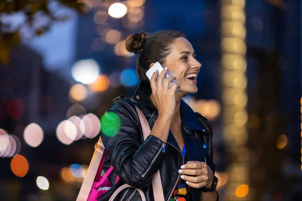 Young woman with smartphone at night in a urban city area