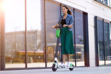 Kaygısız genç kadın elektrikli scooter sürme
