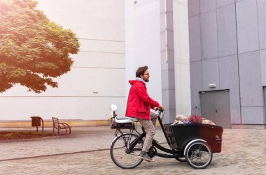 Young man going back from shopping with a cargo bike  clipart