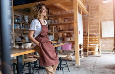 Portrait of woman pottery artist in art studio clipart