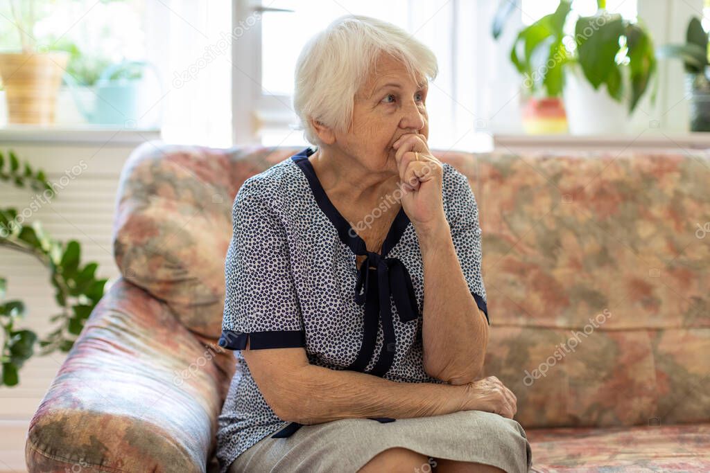 Portrait of an elderly woman in a state of worry at home